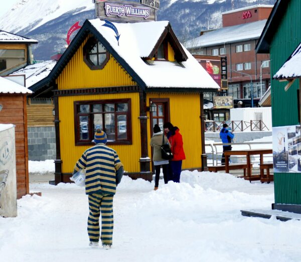 Vibrant winter scene in Ushuaia with colorful houses and snow-covered streets captured outdoors.